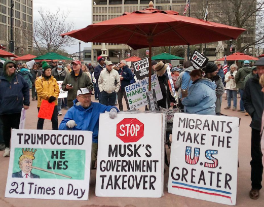 Signs displayed at the "Hands Off!" rally Saturday at Worcester Common Oval.