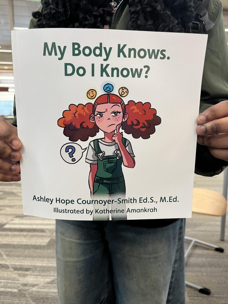 Katherine Amankrah holding her illustrated book.